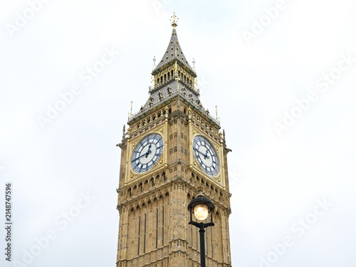 View of the Elizabeth Tower, commonly known as Big Ben, featuring its intricate gothic architecture and clock faces against a bright sky in London, England, United Kingdom.