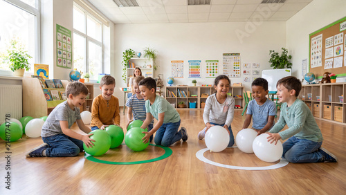 Children sit on the floor in a bright classroom to participate in a group activity involving colorful balloons and organized sorting games for early childhood development.