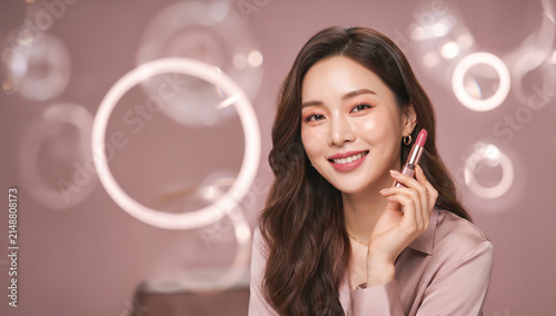 Woman Holding Lipstick in Studio with Bokeh Effect