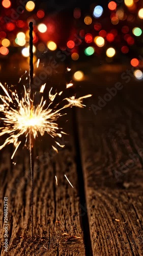 Sparkling Handheld Sparkler Burning on Rustic Wooden Table With Festive Bokeh Lights
