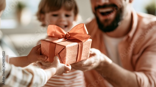 Present offered by child to joyful laughing father indoors