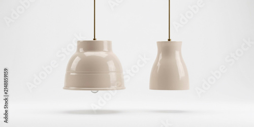Two cream colored pendant lamps with brass hardware on a plain white background