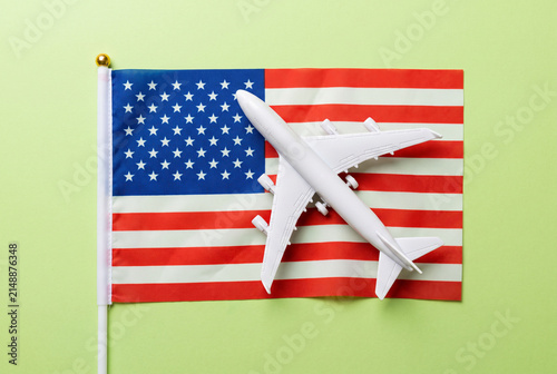 アメリカ合衆国の国旗と模型飛行機で表現する国際航空旅行のコンセプト写真