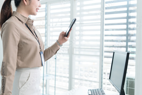 Young Businesswoman Working at Office Desk While Managing Documents and Mobile Communication.