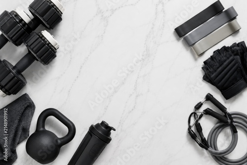 Kettlebell with resistance bands jump rope and yoga mat on marble