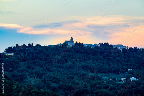 Obraz na płótnie Hilltop town of Mondaino with church and houses silhouetted against pastel sunse