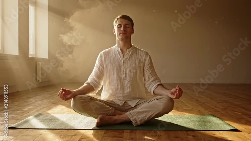 A young man in a tranquil setting practices mindful meditation, fostering inner peace and spiritual harmony amidst soft, natural light, promoting wellness and serenity