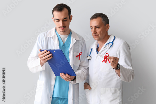 Male doctors with red ribbo...