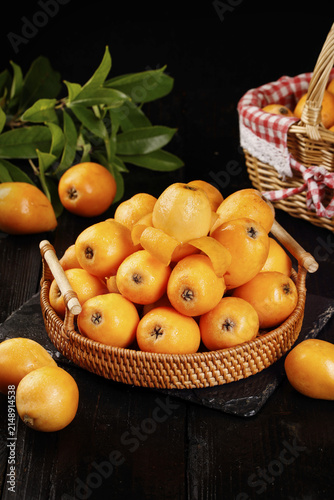 Fresh Yunnan Mountain Loquats in Wicker Basket - Delicious Chinese Fruits on Dark Wood Background