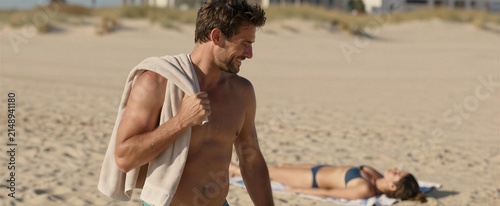 Captures Man In Foreground To Middle Aged With Short Brown Hair Slightly Tousled By Wind Indicating Outdoor Setting Near Beach Given