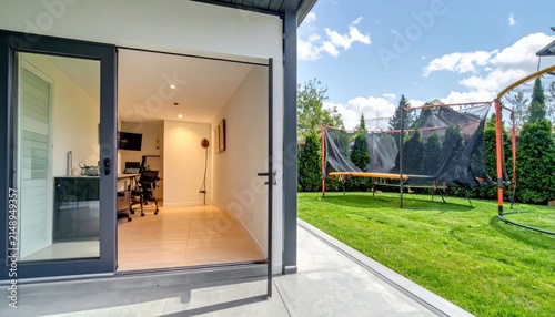 Modern Home Office Opening to Sunny Backyard Patio with Trampoline
