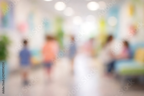 Blurred diverse people walking in bright modern office lobby during casual workplace gathering