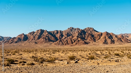 Rugged mountain range rising above a barren desert floor. Excellent for tourism and geography educational graphics.