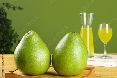 Fresh Thai Pomelo Citrus Fruits with Ruby Juice on Wooden Table Green Background