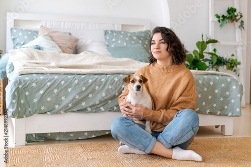 Bild auf Leinwand Calm Woman Holding Her Jack Russell Dog on the Floor at Home