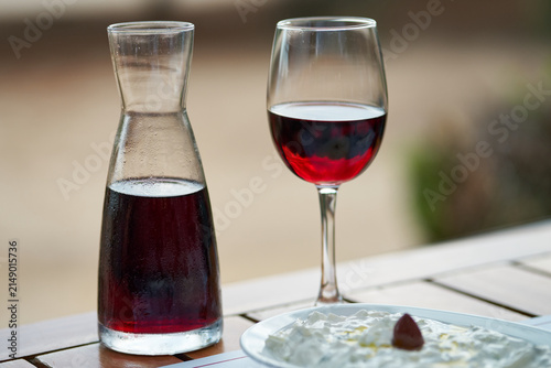 Obraz na plátně Close-up of a glass of red wine and a carafe on a wooden table