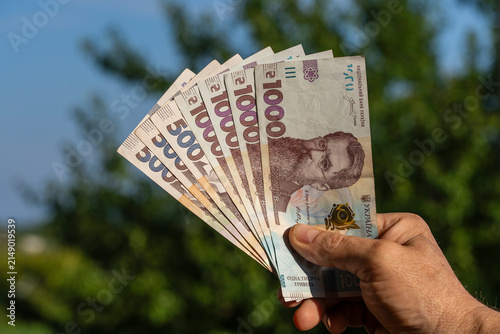 Fotografía Hand holding Ukrainian hryvnia banknotes outdoors