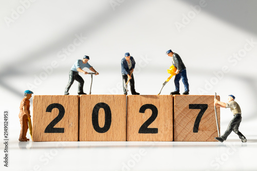 Miniature Construction Workers Building Wooden 2027 Blocks for New Year Business Success Concept