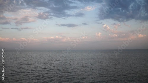 Sunset at cloudly weather in summer, blue sea