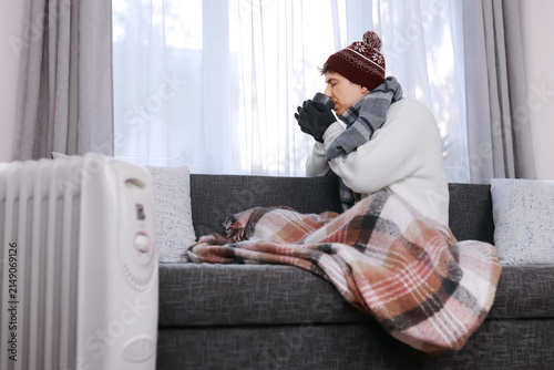 Foto Freezing man at home in winter clothes