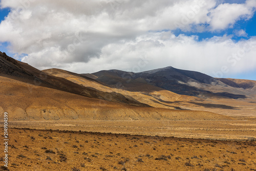 View of the arid terrain and distant mountains near Peiku Cuo in Shigatse, China.