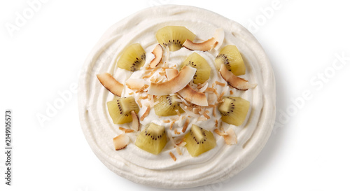 Distant shot of 5 to 10 gold kiwi chunks and coconut flakes half-submerged in thick white coconut cream
