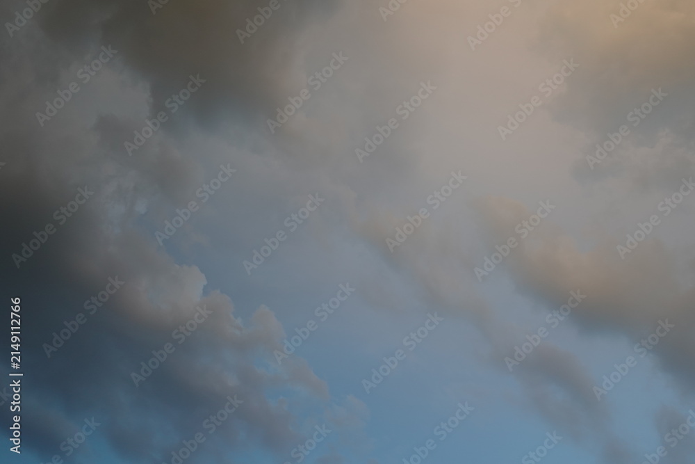 Fototapeta premium Dramatic sky with soft evening clouds and warm sunset light in summer landscape