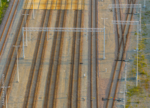 Aerial view of multiple parallel railway tracks with overhead catenary structures and gravel ballast in Gdansk, Pomeranian Voivodeship, Poland.