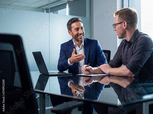 Cuadro en lienzo Two professional businessmen discussing strategies and making notes during a collaborative meeting in a modern office
