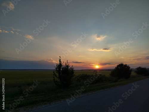Beautiful sunset over rural field landscape in summer