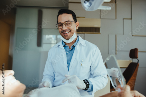 Dentist explaining procedure to patient during dental checkup