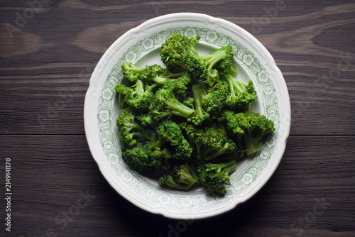 Plate of boiled broccoli on wooden table