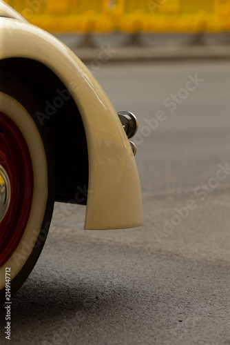 Canvastavla Tight view of a cream-colored vintage car showing the rear fender, chrome bumper