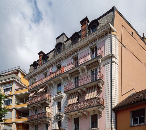 Residential building in Montreux, Switzerland, features typical 19th-century architecture including a mansard roof and ornate iron balconies.