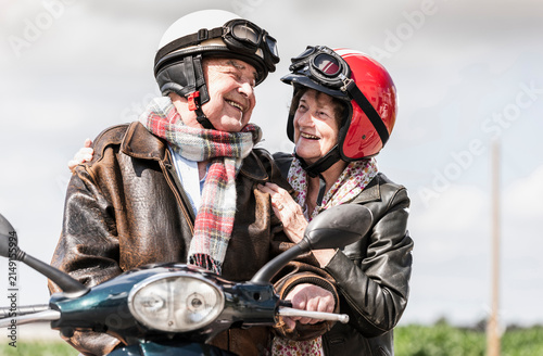 Happy senior couple riding motor scooter