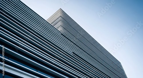 Abstract Architectural Perspective of Modern Corporate Office Building with Linear Metal Facade and Clear Blue Sky Background