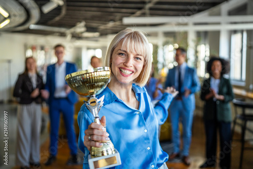 Canvas Print Businesswoman celebrating success winning a golden trophy