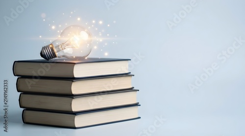 Glowing light bulb shining on a stack of books, representing knowledge and wisdom on a plain light background with bokeh particles floating in the air