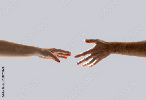 Helping hand gesture composition isolated over gray background. Closeup two hands reaching to each other. Concept for salvation, rescue, friendship, guidance, help, helping