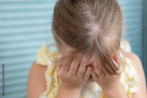 little girl holding hands on head having headache, child feeling sick or stressed, pediatric health problem, migraine emotion, pain expression, close up child sadness portrait, emotional pain