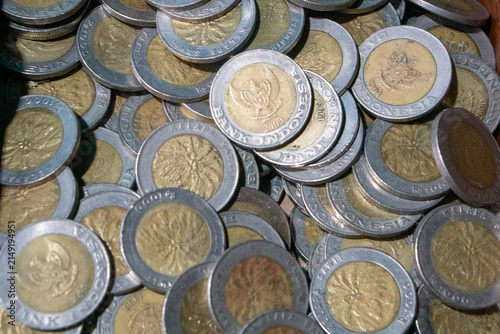 Stack of Indonesian Rp1,000 coins featuring the oil palm tree design these were first issued in 1993 and had their status as legal tender revoked by Bank Indonesia in 2023. 