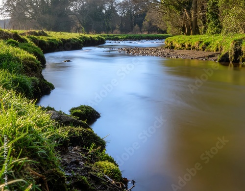 Serene river winding through lush green forest landscape.
