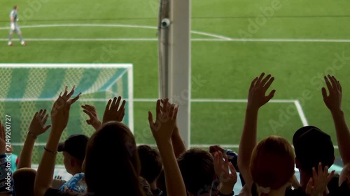 Silhouettes of wild fans jumping at the football stadium.