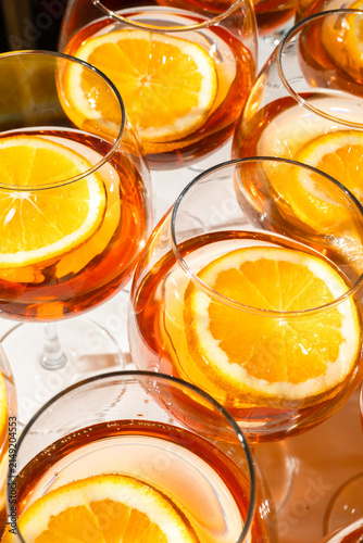 Glasses filled with an amber cocktail and fresh orange slices are captured in close up under bright studio lighting for a premium beverage presentation