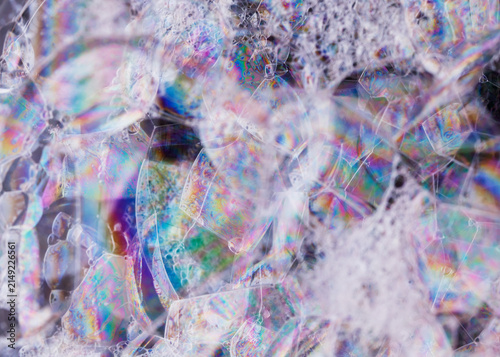 Energetic abstract of soap bubbles forming a textured, translucent mosaic of pastel spectra.