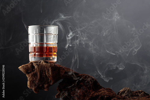 Smoked old-fashioned cocktail on weathered driftwood.