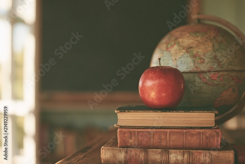 Vintage classroom scene with apple on books and globe, symbolizing education