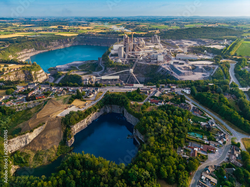 Aerial view of CCB Granulats Gaurain industrial facility featuring deep blue quarry lakes, processing infrastructure, and surrounding greenery in Tournai, Wallonia, Belgium.