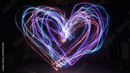 Dynamic Light Painting Swirls Forming a Glowing Heart Shape in Dark Space