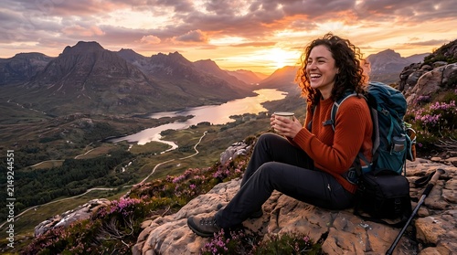 Woman sitting on mountain rocks overlooking a sunset landscape